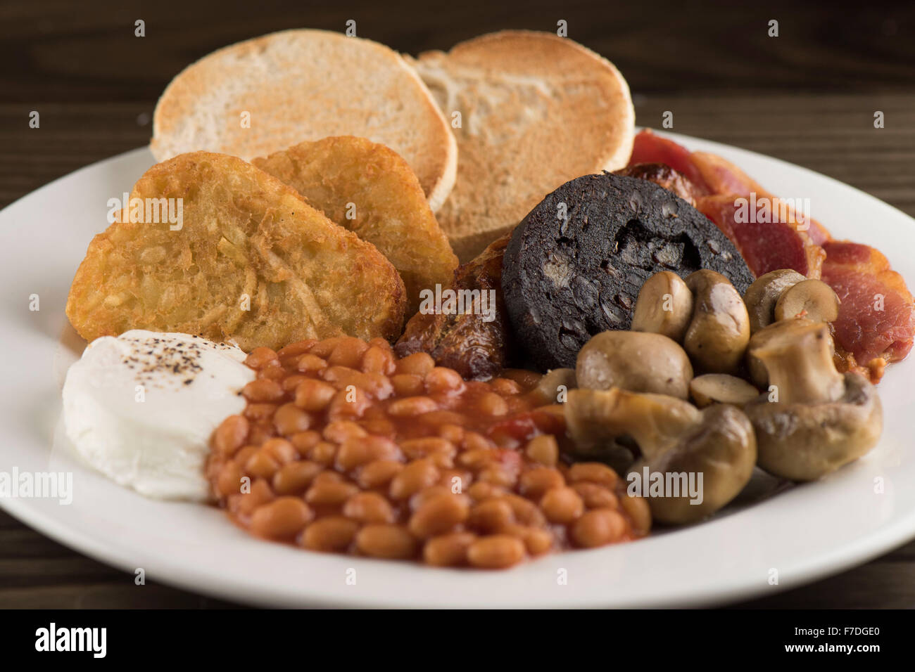 Un petit-déjeuner anglais traditionnel dimanche composé de haricots, champignons, saucisses, boudin noir, muffins anglais oeuf et bacon. Banque D'Images