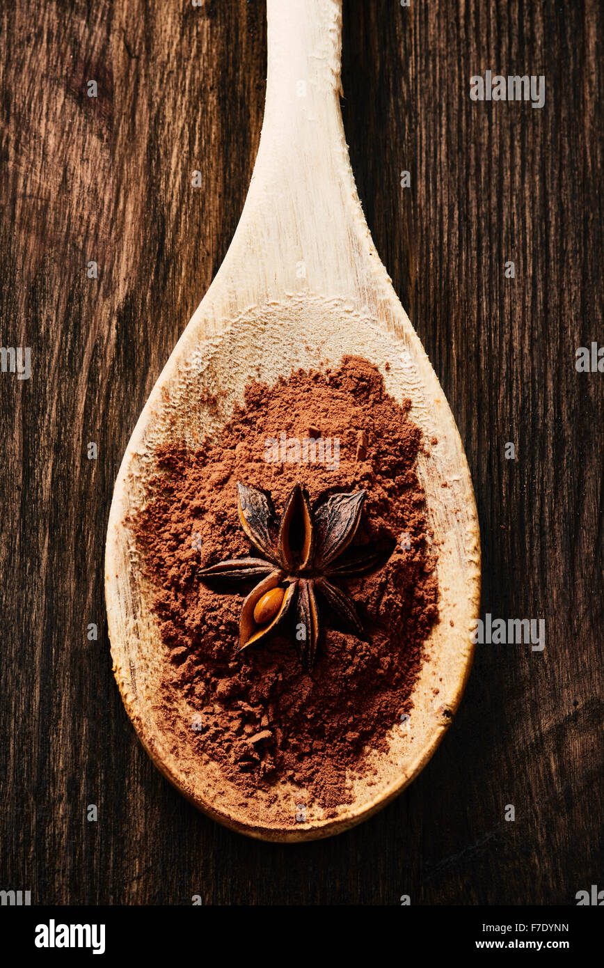 L'anis étoilé sur le cacao et cuillère en bois sur la table en bois Banque D'Images