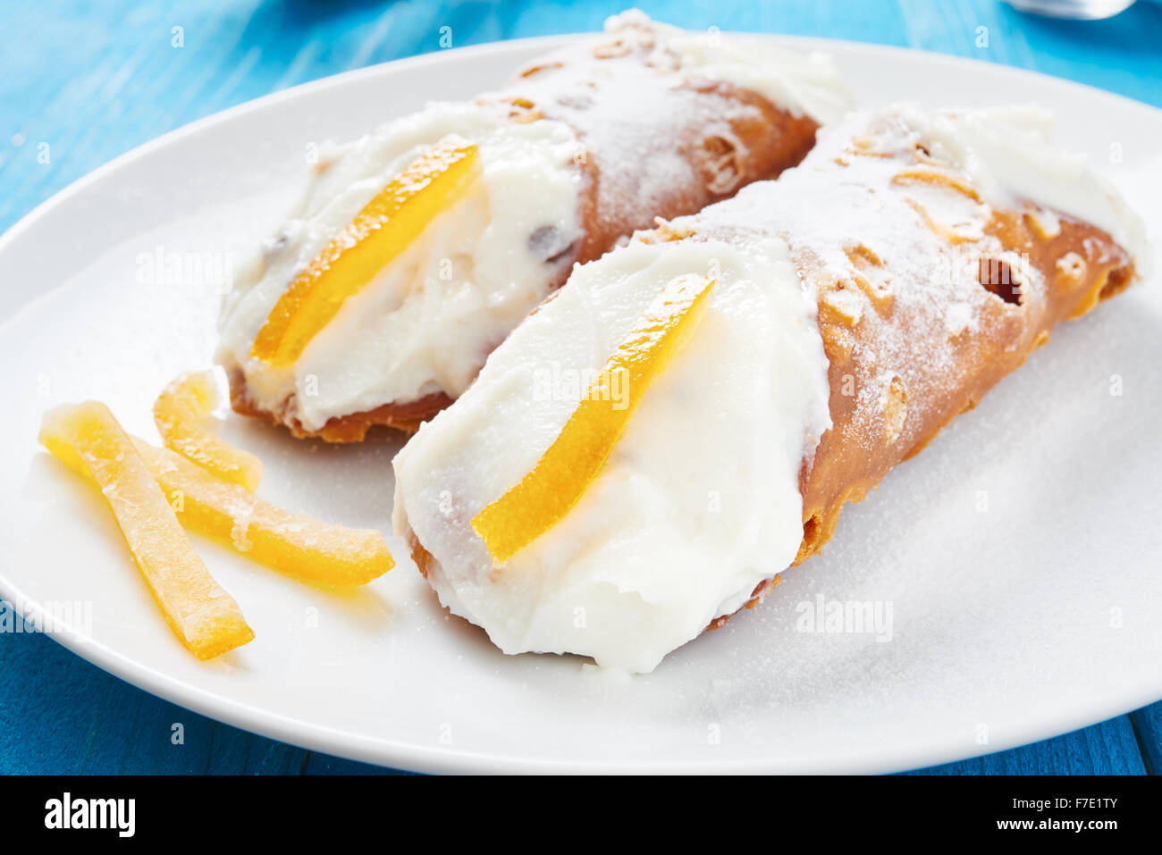 Cannoli siciliens sur plaque blanche et bleu table en bois Banque D'Images