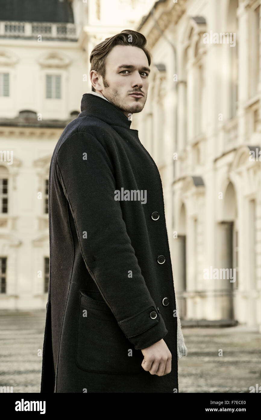 La mode homme portant beau manteau foncé extérieur permanent dans la ville  européenne avec un élégant bâtiment historique vieux derrière lui Photo  Stock - Alamy