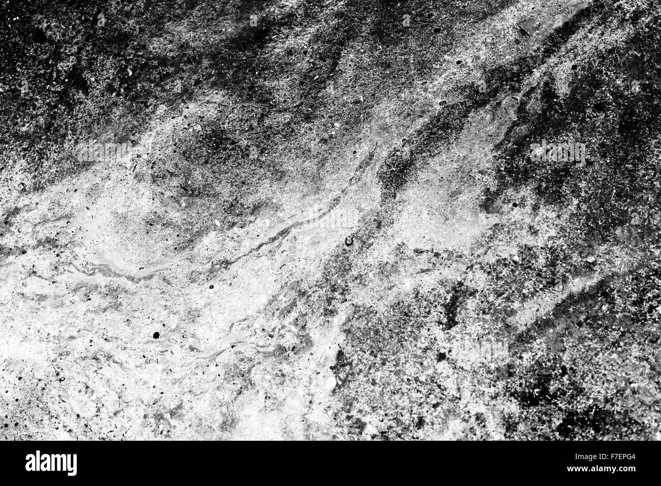 J'ai pris cette photo pendant un jour de pluie. Un bassin d'huile moteur qui fuit s'était formée à la surface d'une flaque, et j'ai trouvé l'swirls Banque D'Images