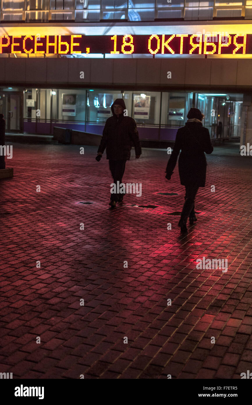 Deux personnes marchant sur une pluie rue le soir dans une ville Banque D'Images