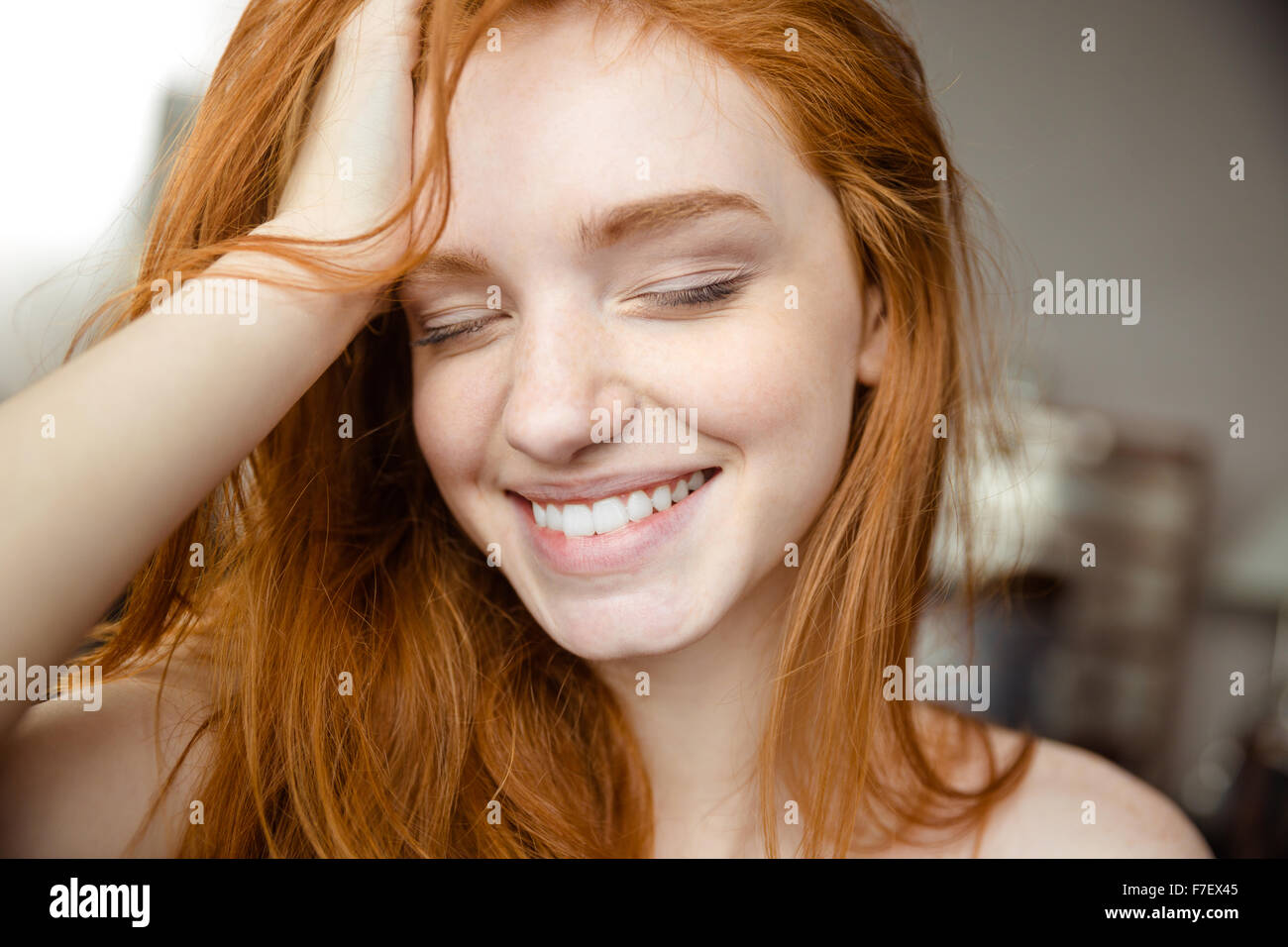 Closeup portrait of a smiling redhead woman with closed eyes Banque D'Images