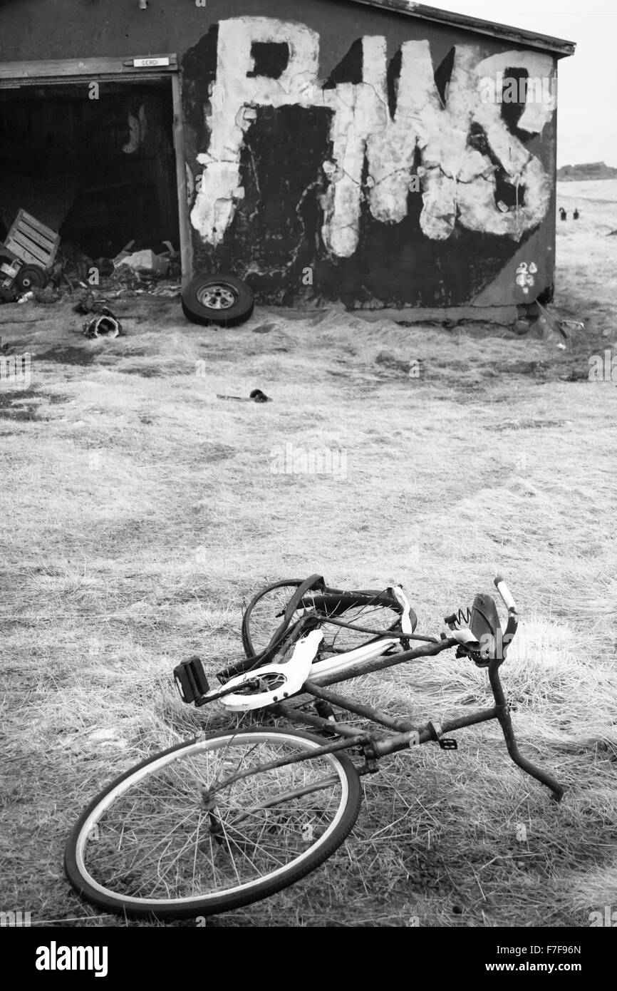 Bâtiments abandonnés et vélo à Hafnarnes Fáskrúðsfjörður, Faskrudsfjordur, est de l'Islande en février - noir et blanc noir et blanc monochrome Banque D'Images