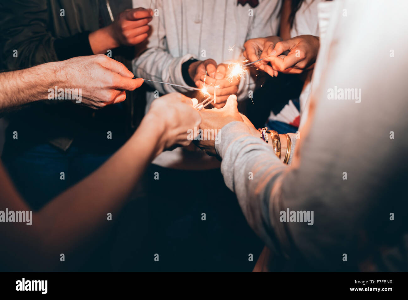 Gros plan des cierges dans les mains des jeunes. Best Friends celebrating New Year's Eve holding sparklers, dans une partie. Banque D'Images