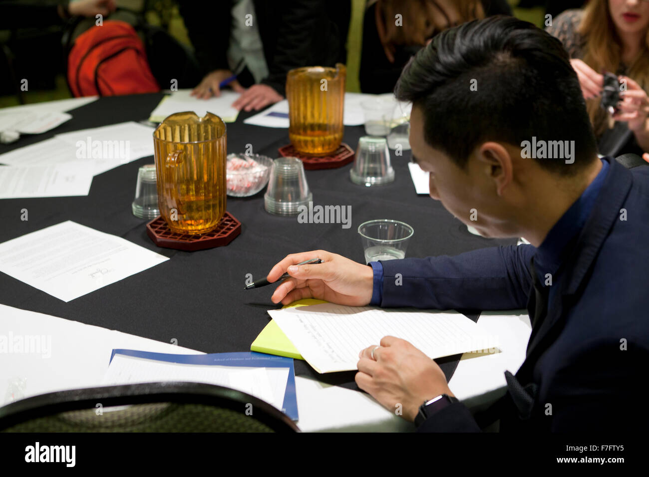 Young Asian man remplissant une demande d'accès à l'emploi Foire de recrutement - Arlington, Virginia, USA Banque D'Images