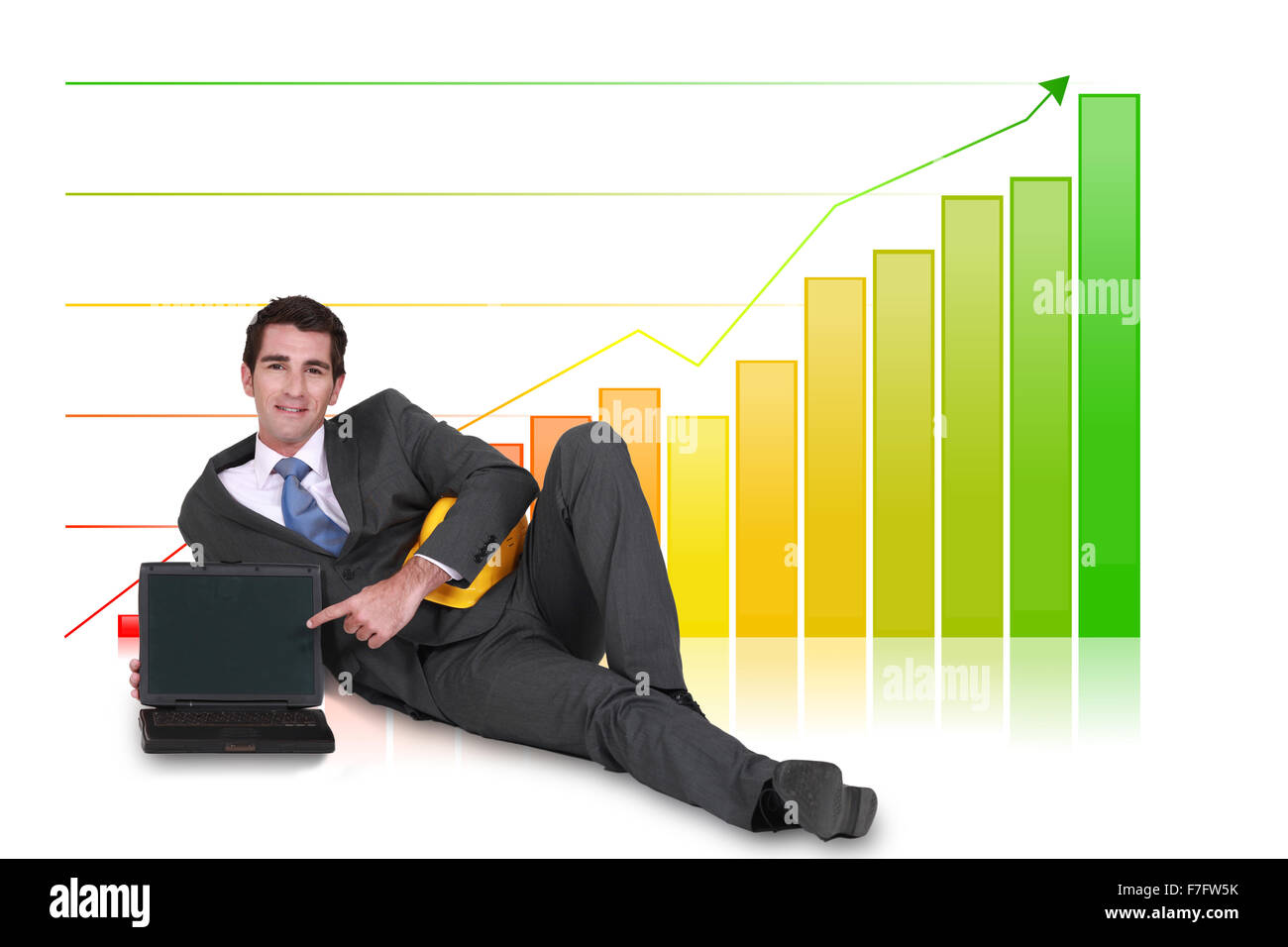 Pose d'affaires avec ordinateur portable en face de diagramme à barres Banque D'Images