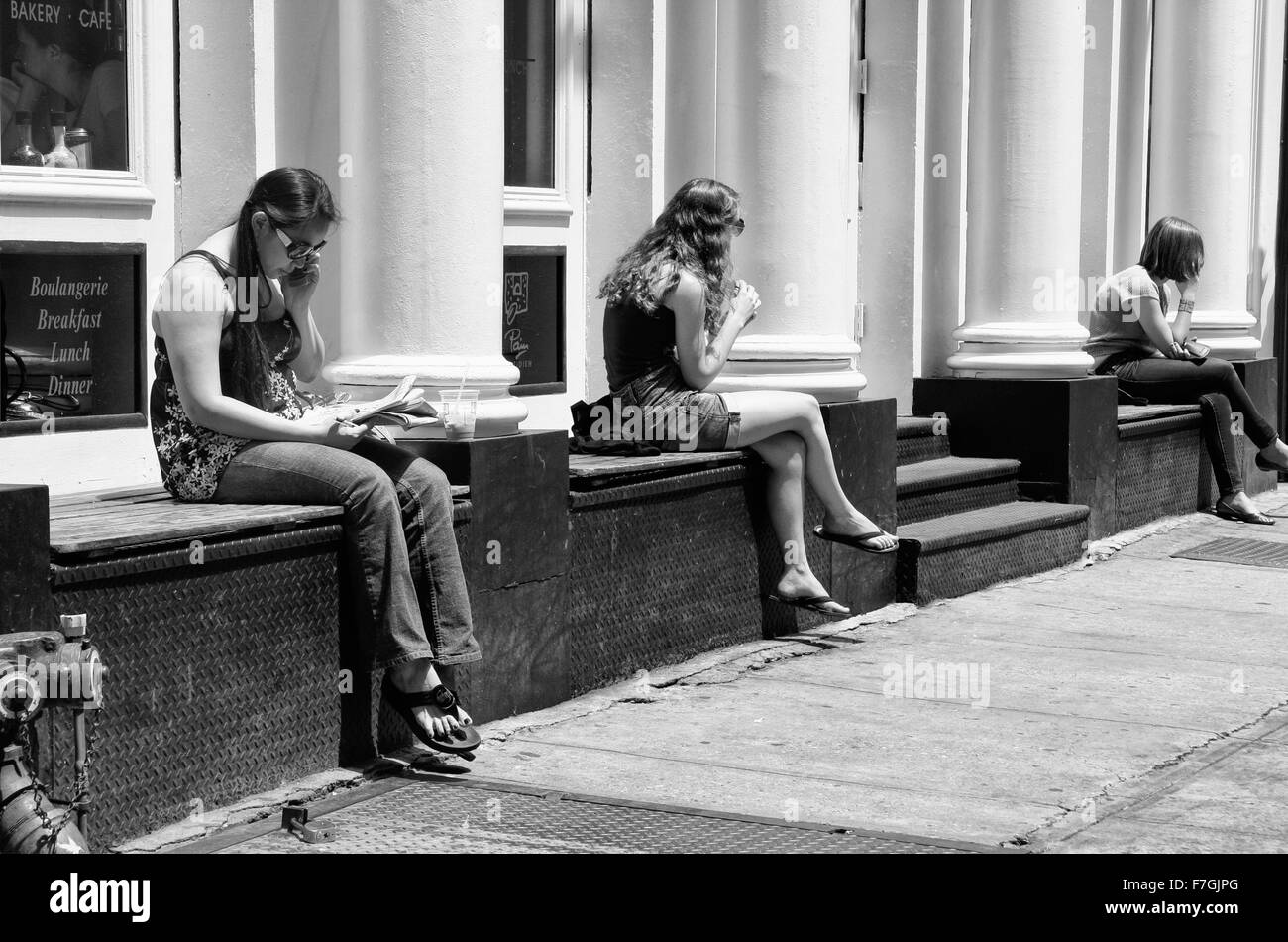 NEW YORK - Le 24 juin : Trois jeunes filles assis sur banc magasin à Soho. Juin 24nd, 2008 à New York, USA. Anciens bâtiments industriels ont Banque D'Images