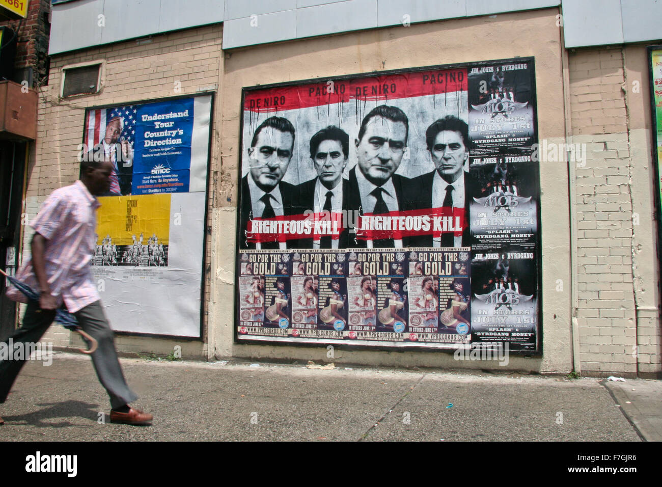 HARLEM, NEW YORK, juin 2008 : Un homme marche à côté de affiches dans Harlemi, le 22 juin 2008, à New York City Banque D'Images HARLEM, NEW YORK, juin 2008 : Un homme marche à côté de affiches dans Harlemi, le 22 juin 2008, à New York City Banque D'Images