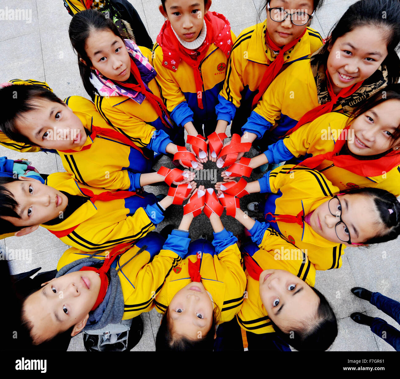La Chine Shangrao, province de Jiangxi. 1er décembre 2015. Les élèves montrent les rubans rouges, le symbole de la sensibilisation au VIH/SIDA, pour marquer la Journée mondiale du sida en Chine orientale, Ville Dexing Jiangxi Province, du 1 décembre 2015. La Journée mondiale du sida, qui a commencé en 1988, est célébrée chaque année le 1er décembre pour élever la conscience de SIDA. Credit : Zhuo Zhongwei/Xinhua/Alamy Live News Banque D'Images