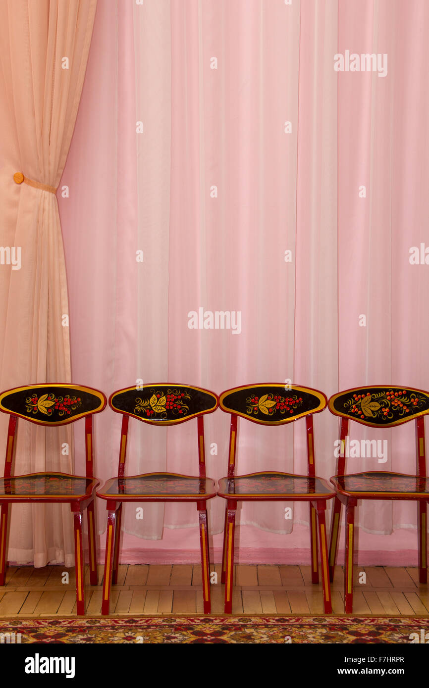 Arrière-plan de rideau rose avec quatre chaises enfants Banque D'Images