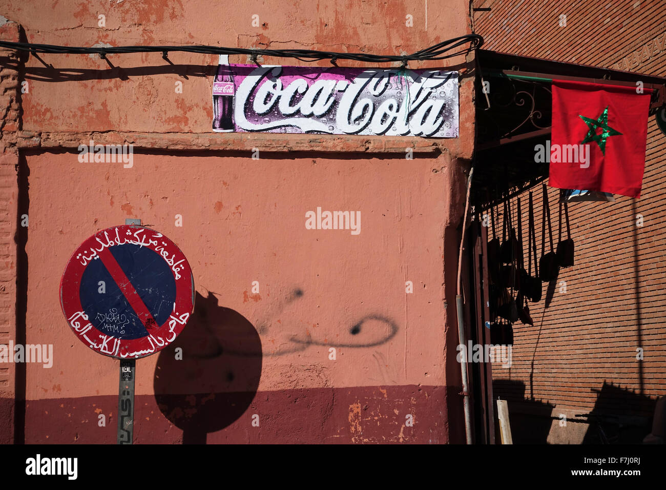 Marrakech, Maroc. 07Th Nov, 2015. L'étiquette de Coca-Cola sur un mur entre un panneau d'arrêt et le drapeau marocain dans la vieille ville de Marrakech, Maroc, 07 novembre 2015. Photo : Jens Kalaene - AUCUN FIL - SERVICE/dpa/Alamy Live News Banque D'Images