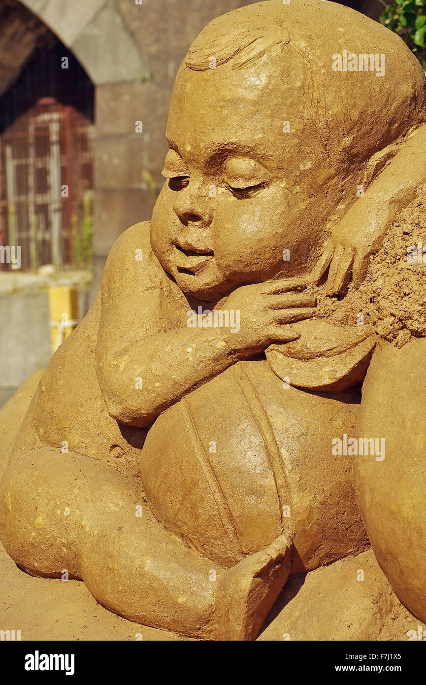 Festival de sculptures de sable 'Treasure Island' à Saint - Pétersbourg, le 3 août 2014.Sculpture d'un petit enfant un assis parmi les jouets. Banque D'Images