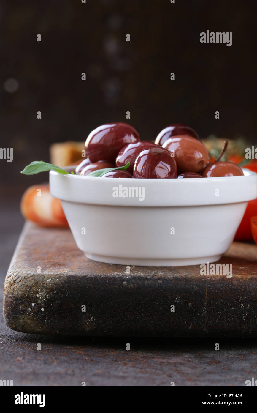 La nourriture italienne still life - olives, tomates, basilic, jambon prosciutto Banque D'Images