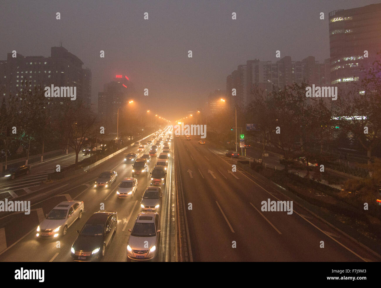 Les personnes qui voyagent dans l'air brumeux portent des masques car elles braquent des records de pollution de l'air dans la capitale chinoise, qui a grimpé jusqu'à 35 fois le niveau de sécurité. © Olli Geibel Banque D'Images