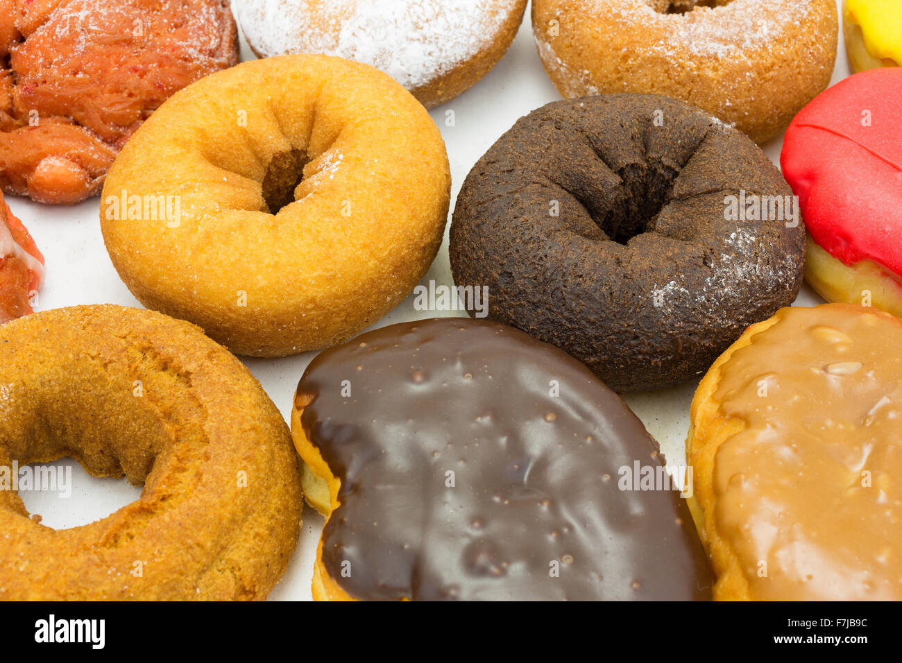 Fermer la vue d'un groupe de variétés de donuts et beignets glacés de bars dans le fond d'une boîte en carton. Banque D'Images