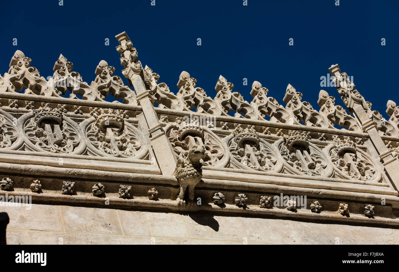 Gargouille sur un mur de la Cathédrale de Grenade en Espagne, avec la maçonnerie orné sur le toit derrière et un ciel bleu Banque D'Images