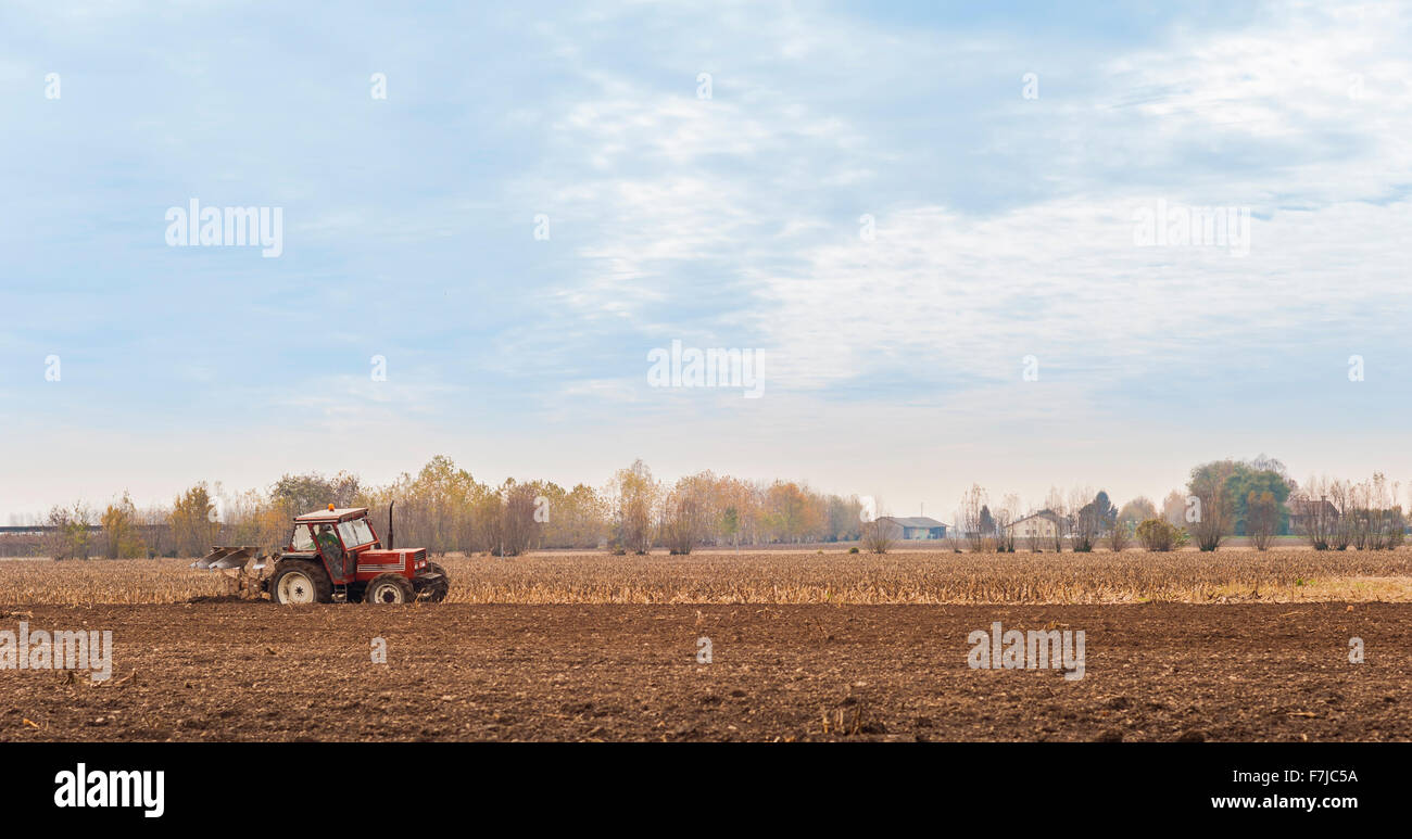 Le tracteur laboure un champ avec une charrue. Banque D'Images