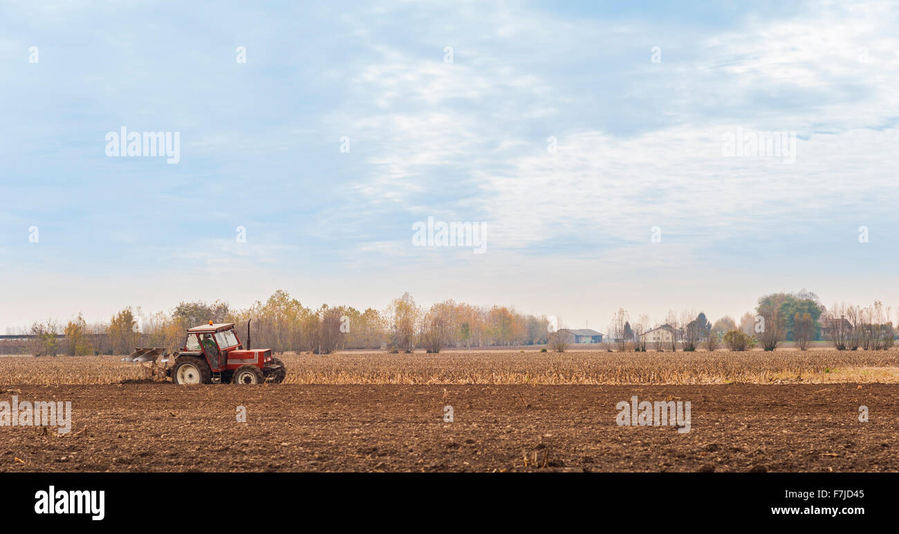 Le tracteur laboure un champ avec une charrue. Banque D'Images