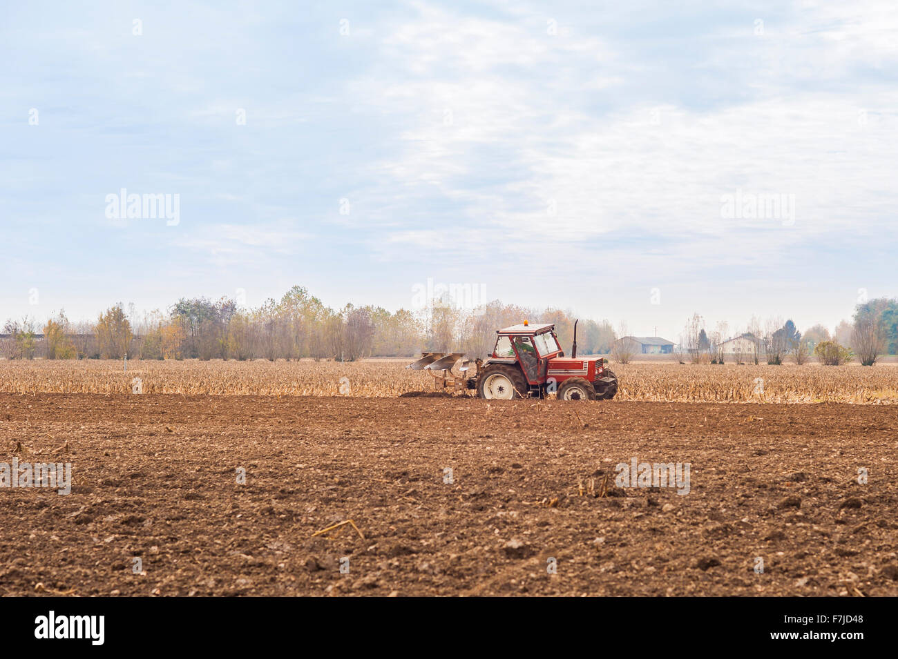 Le tracteur laboure un champ avec une charrue. Banque D'Images