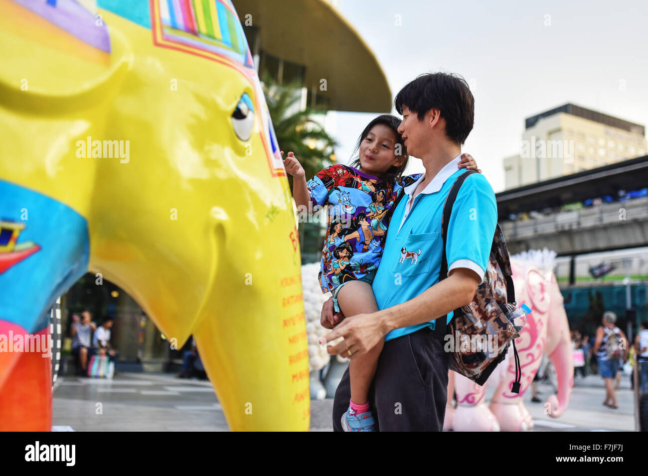 Bangkok, Thaïlande. 1er décembre 2015. Un homme et sa fille regardez sur une statue d'éléphant de couleur au cours de la 'Elephant Parade Bangkok 2015" Exposition en plein air au centre-ville de Bangkok, capitale de la Thaïlande, le 1er décembre 2015. Quatre-vingt-huit statues d'éléphants colorés créés par divers artistes et célébrités ont été mis sur le spectacle à Bangkok lundi. Organisé par l'Elephant Parade, une entreprise sociale, 'Elephant Parade Bangkok 2015" vise à accroître la sensibilisation pour la conservation et le bien-être de l'éléphant d'Asie, une espèce en voie de disparition. Source : Xinhua/Alamy Live News Banque D'Images