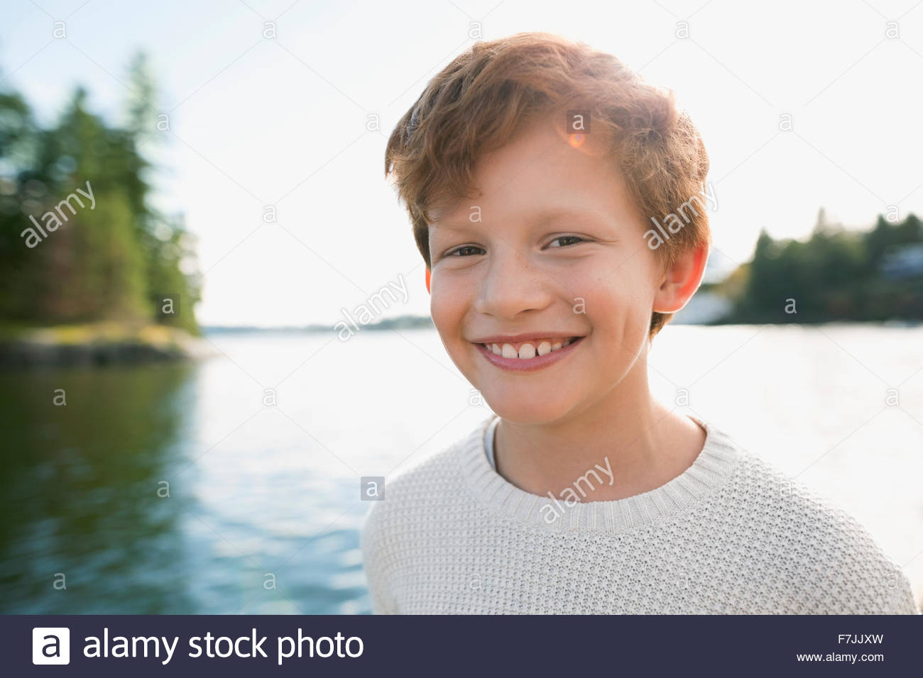 Portrait of smiling boy with red hair at lakeside Banque D'Images