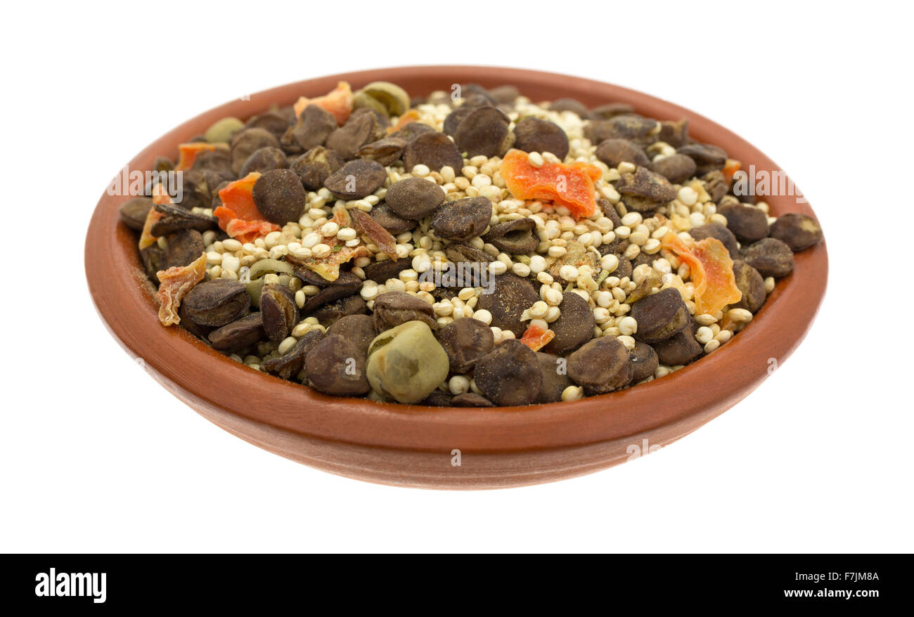 Un petit bol rempli avec les ingrédients secs pour la soupe aux lentilles quinoa isolé sur un fond blanc. Banque D'Images
