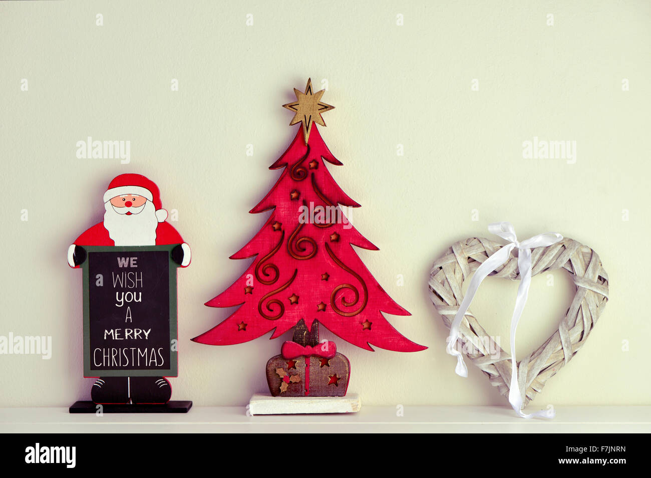 Une ardoise en forme de père Noël avec le texte que nous vous souhaitons un joyeux Noël, un arbre de Noël en bois rustique et une rusti Banque D'Images