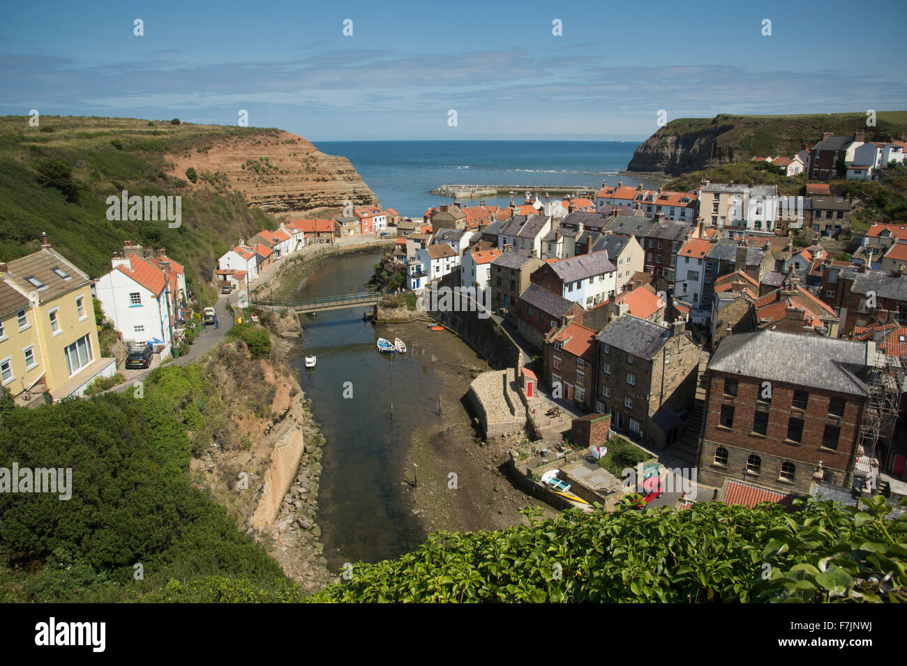 Ensoleillé, vue sur haute, Staithes pittoresque North Yorkshire, GB, UK - Station balnéaire pittoresque village avec des chalets blottis, port naturel et bleu ciel. Banque D'Images