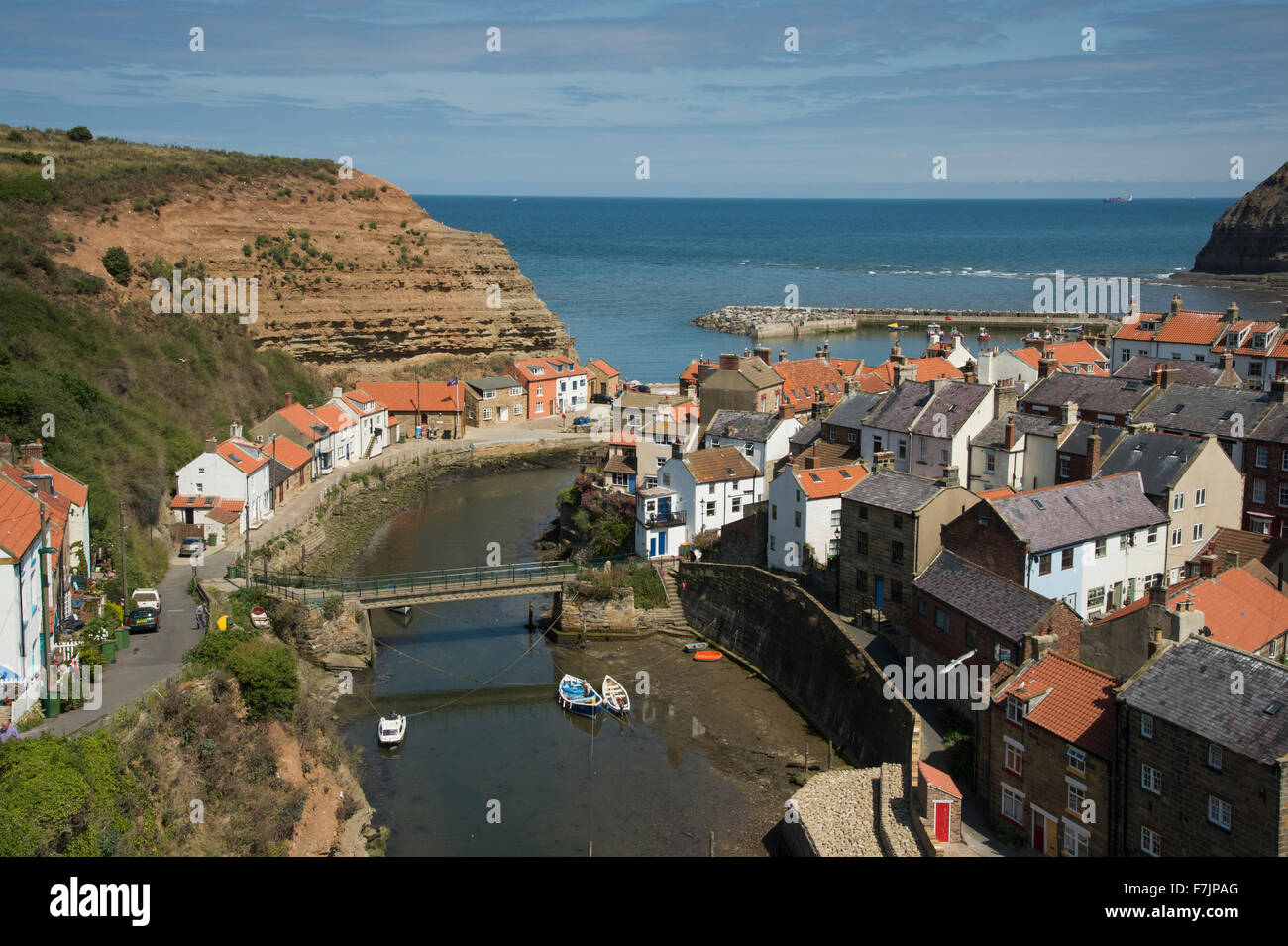 Ensoleillé, vue sur haute, Staithes pittoresque North Yorkshire, GB, UK - Station balnéaire pittoresque village avec des chalets blottis, port naturel et bleu ciel. Banque D'Images