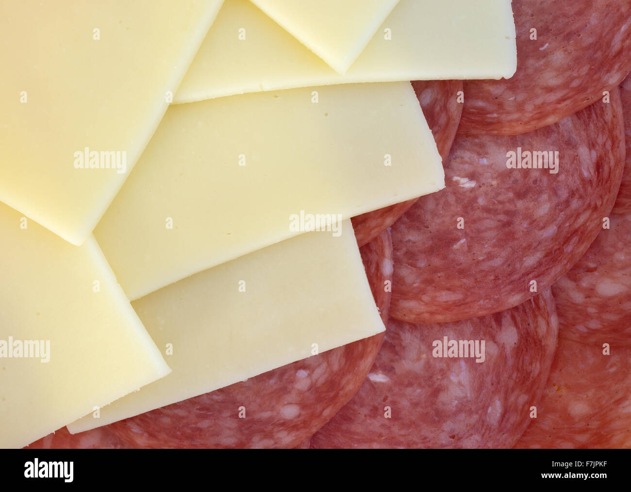 Un gros plan de tranches de salami de Gênes et de fromage provolone illuminé par la lumière naturelle. Banque D'Images