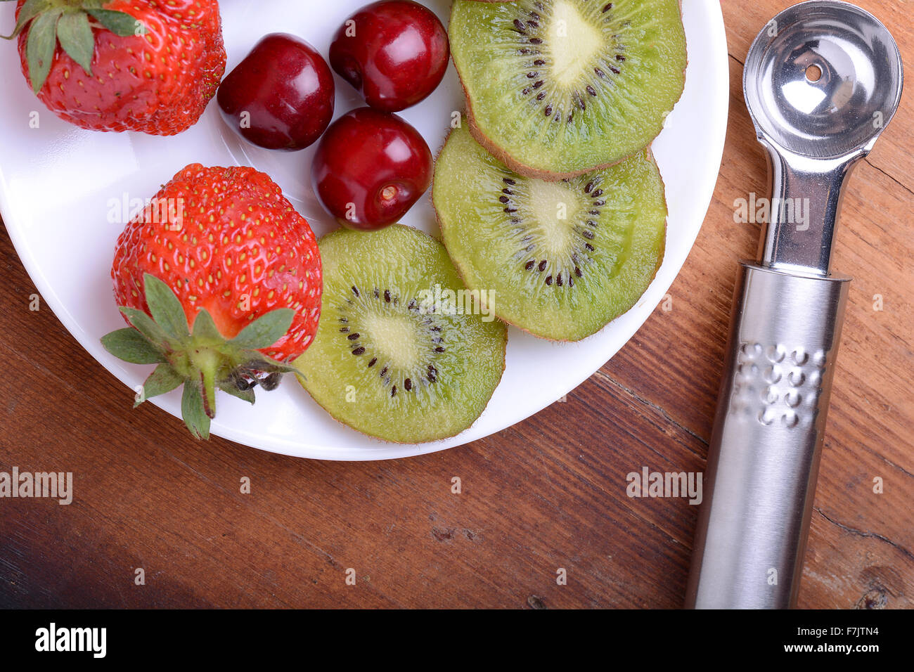 Fruit avec cerise, fraise, kiwi sur plaque de bois Banque D'Images