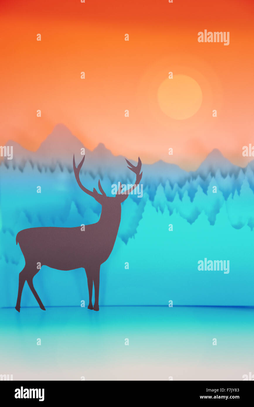 Coupe papier avec illustration des vacances d'hiver au chevreuil dans la forêt et fond de ciel coucher de soleil. Idéal pour les cartes de vœux de Noël Banque D'Images