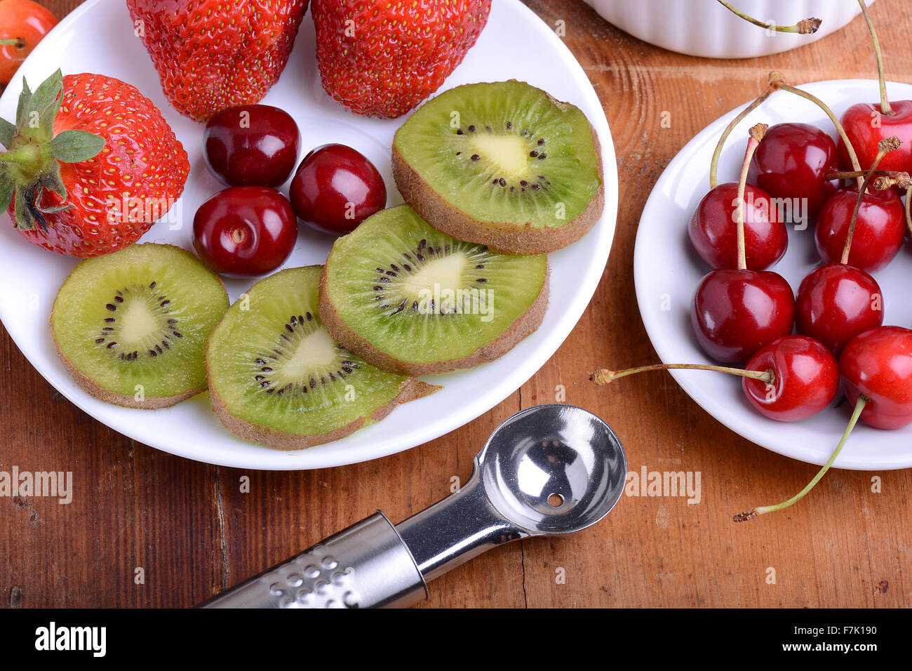 Fruit avec cerise, fraise, kiwi sur plaque de bois Banque D'Images