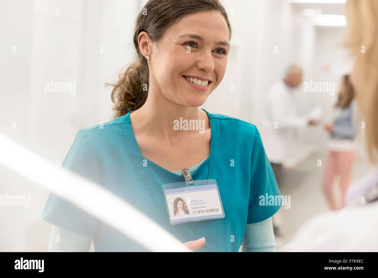 Smiling nurse talking to doctor in hospital corridor Banque D'Images