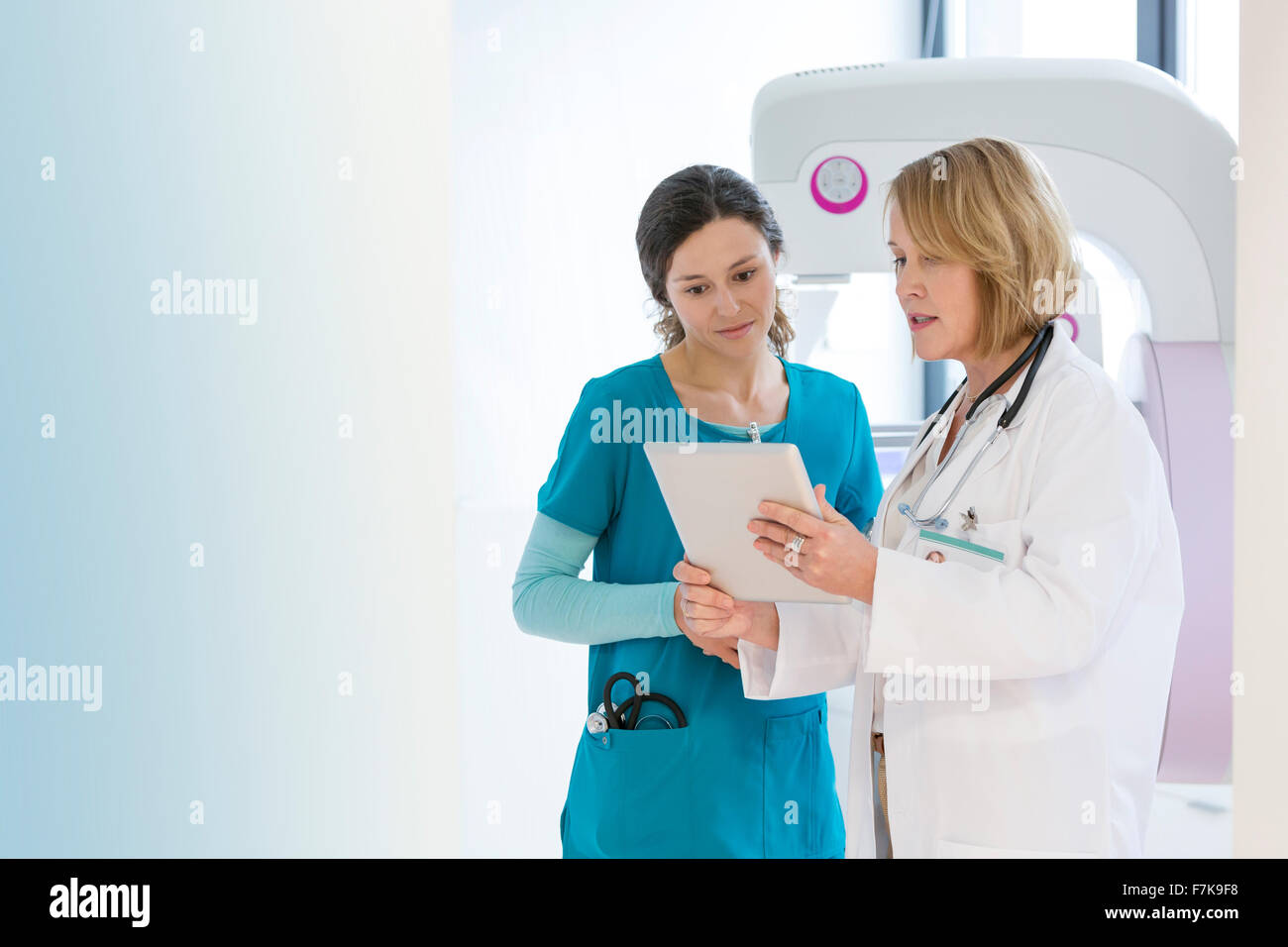 Doctor and nurse using digital tablet in examination room Banque D'Images