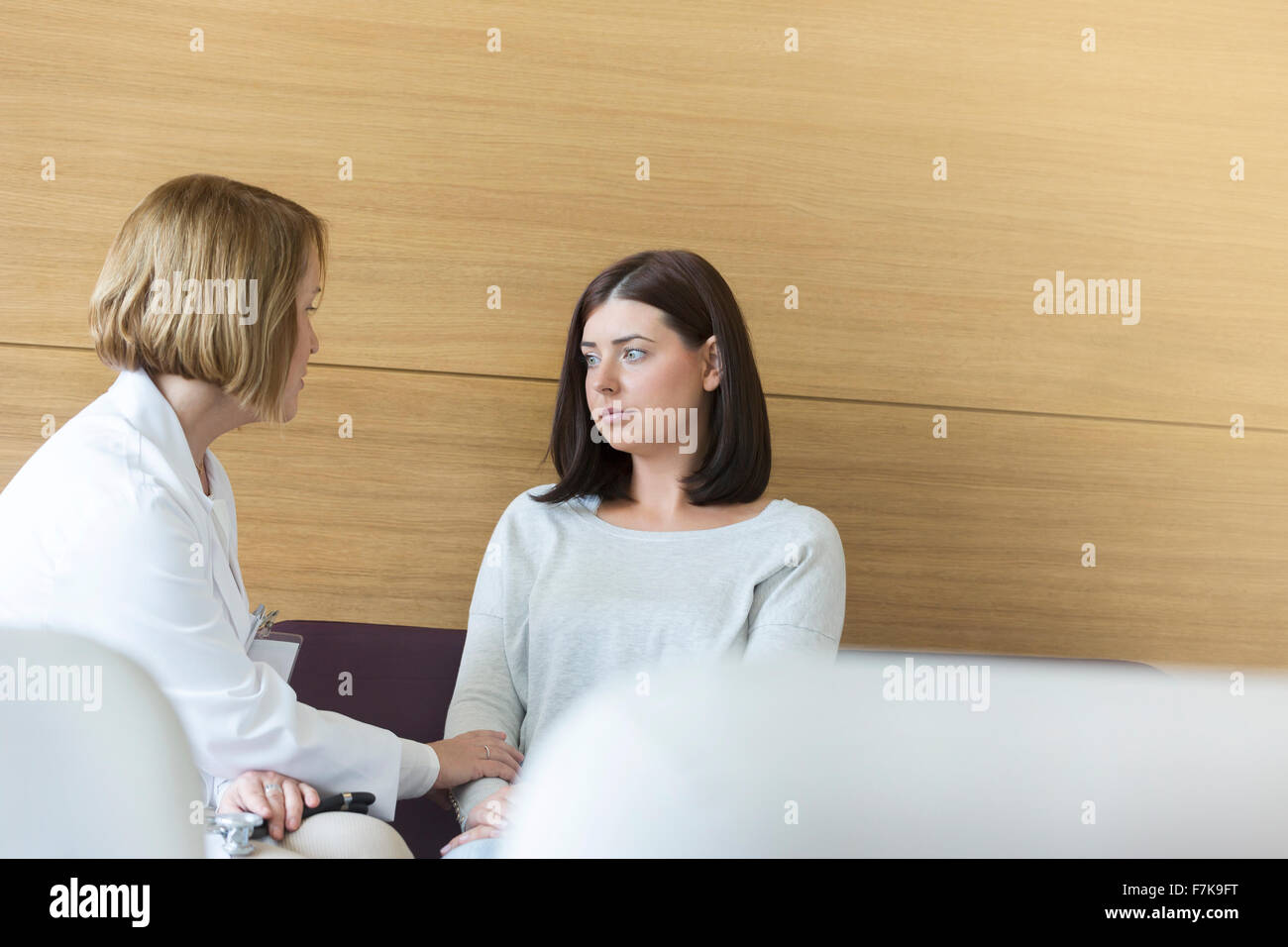 Médecin sérieux consolant patient dans un centre hall Banque D'Images