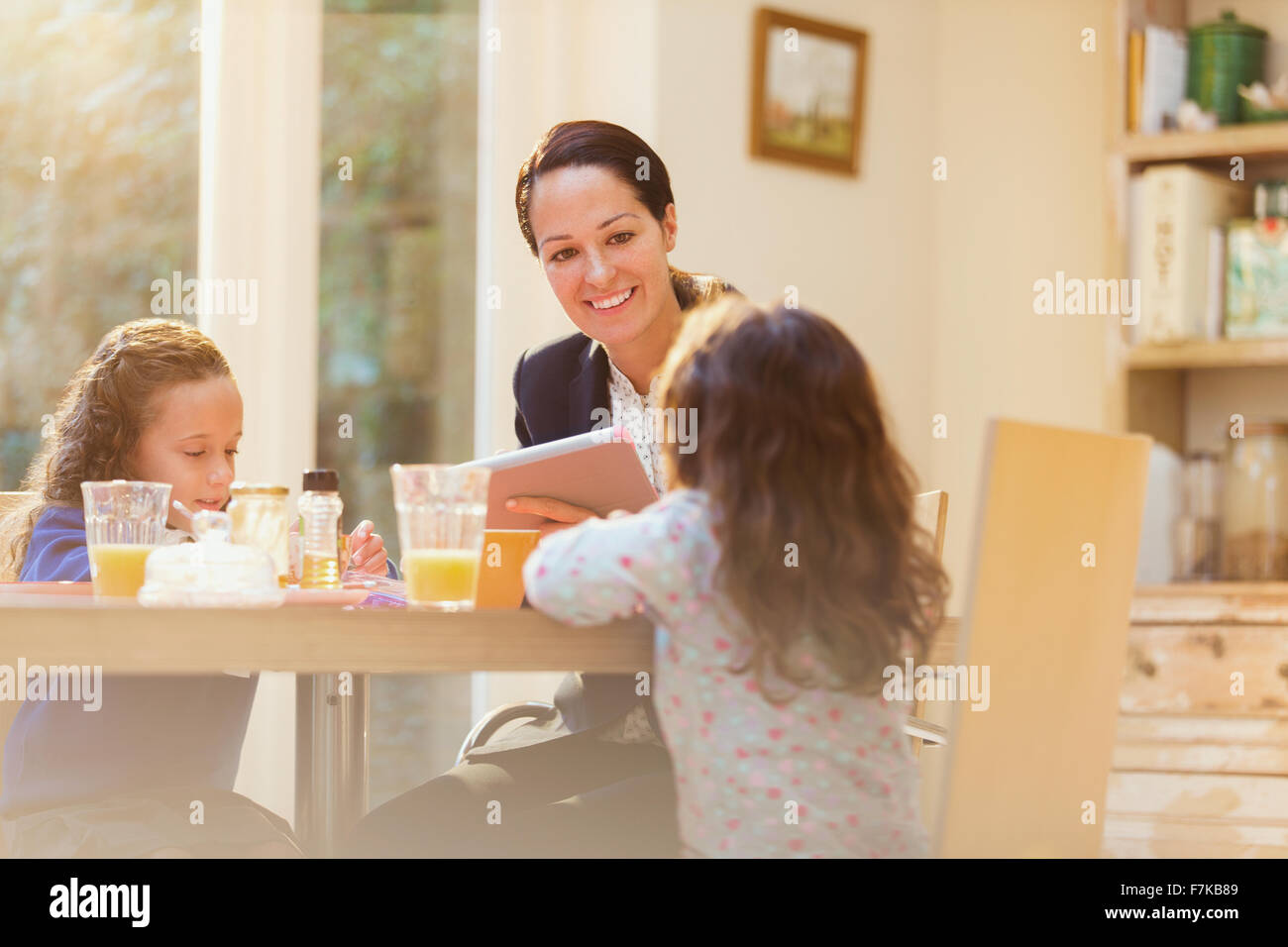 Mère et filles à la table du petit déjeuner Banque D'Images
