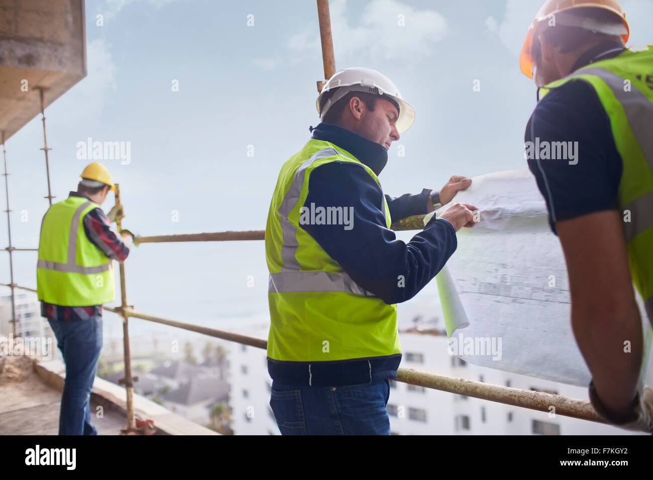 Travailleur de la construction et de l'ingénieur l'examen blueprints à highrise construction site Banque D'Images