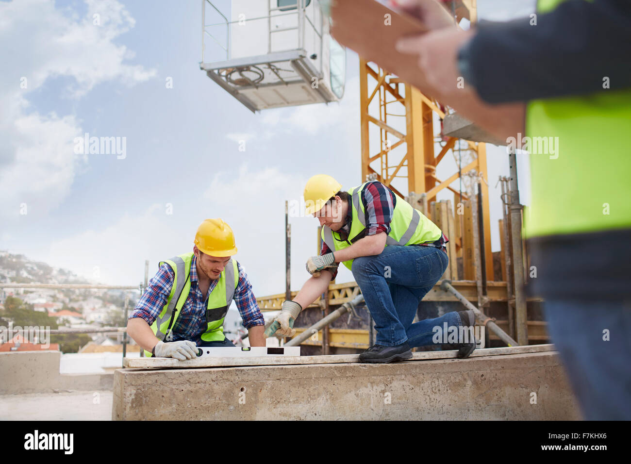 Les travailleurs de la construction à l'aide de l'outil niveau at construction site Banque D'Images