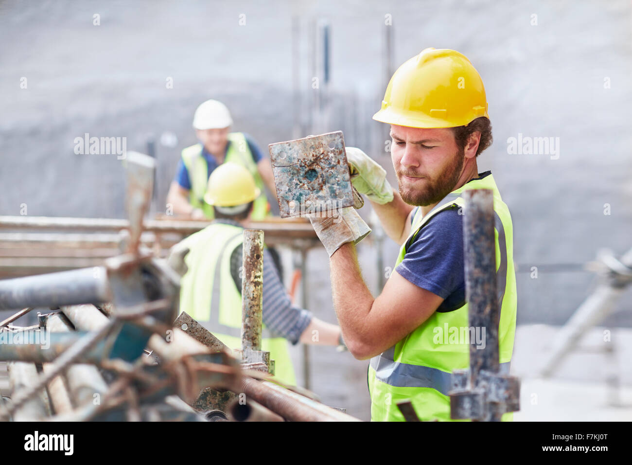 Construction Worker carrying metal bar at construction site Banque D'Images
