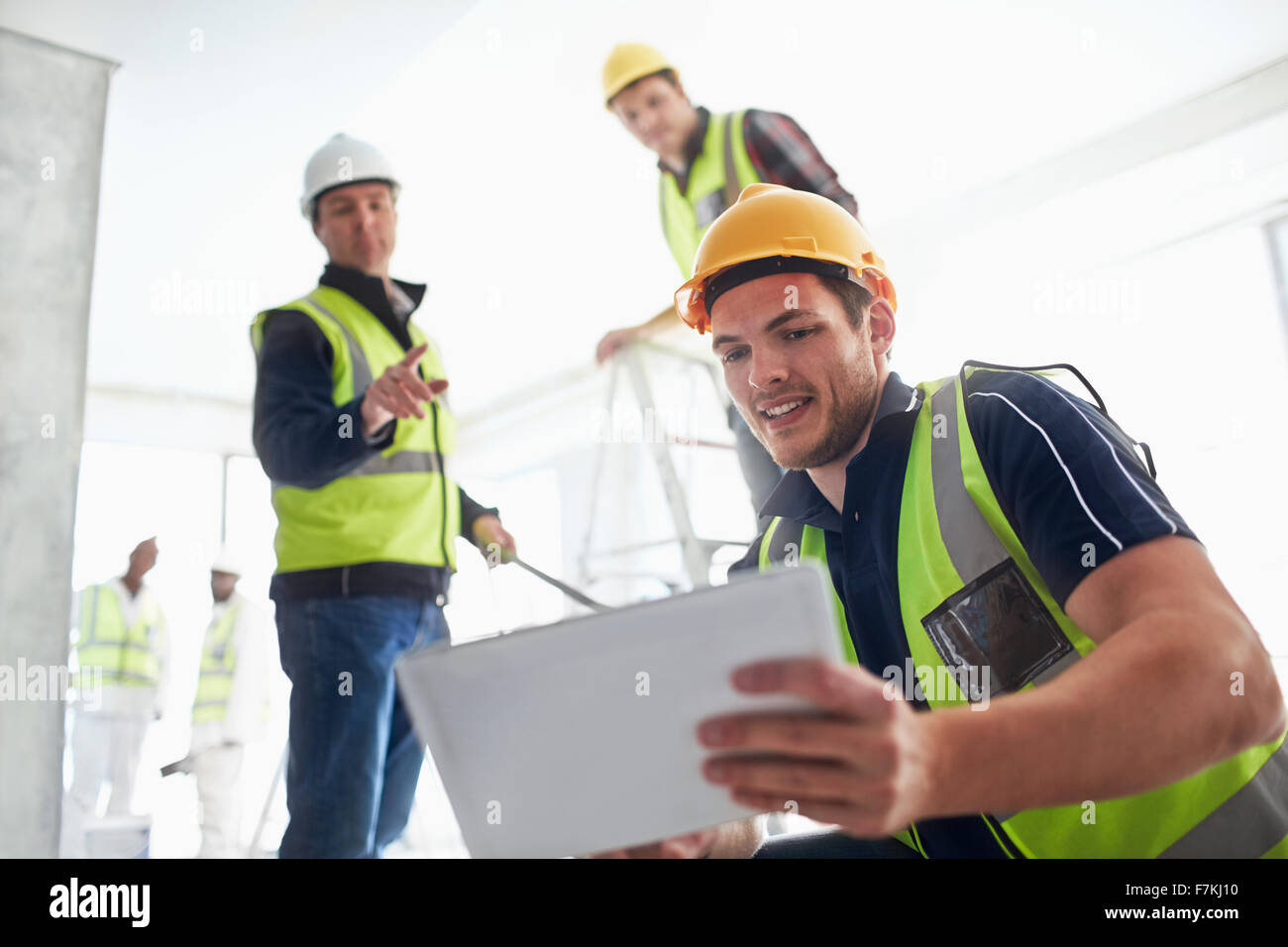 Les travailleurs de la construction with digital tablet at construction site Banque D'Images