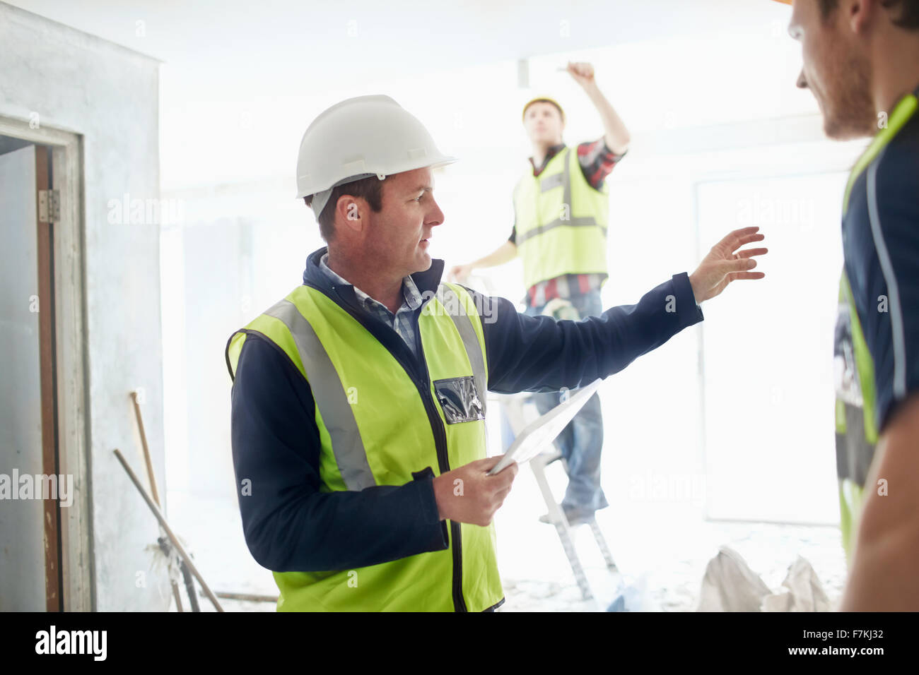 Foreman avec tablette numérique désignant construction worker at construction site Banque D'Images