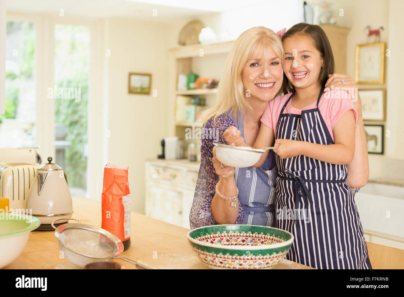 Portrait smiling grandmother and granddaughter baking in kitchen Banque D'Images