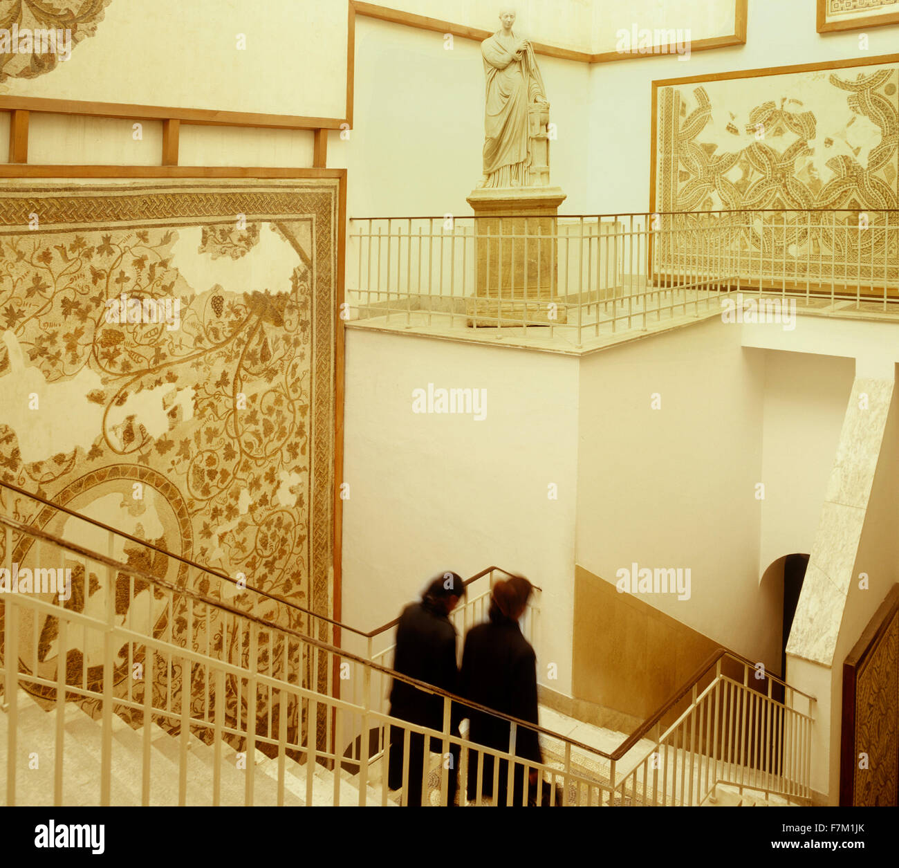 Deux femmes tunisiennes descendre un escalier d'une mosaïque et statue exposée au Musée du Bardo à Tunis. Le Bardo, situé dans le Banque D'Images