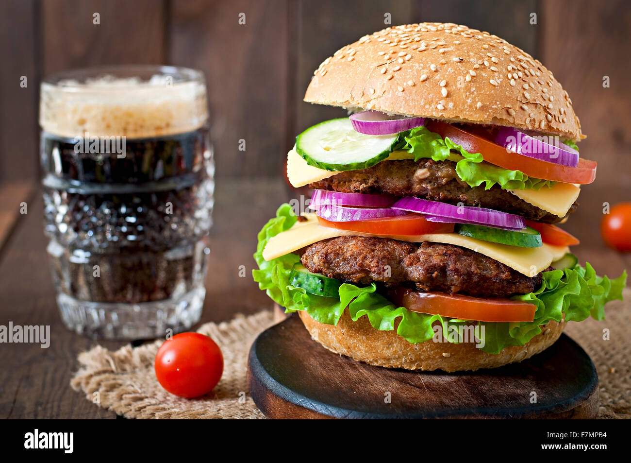 Hamburger juteux avec des légumes et de la viande bovine sur un fond de bois dans un style rustique Banque D'Images