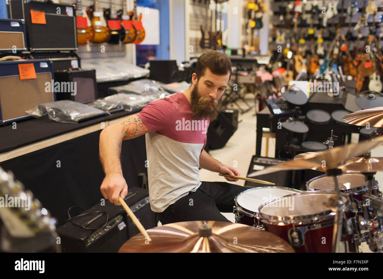 Musicien masculin jouant des cymbales au music store Banque D'Images