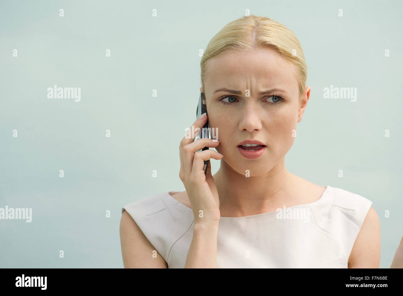 Femme qui reçoit une mauvaise nouvelle on cell phone Banque D'Images