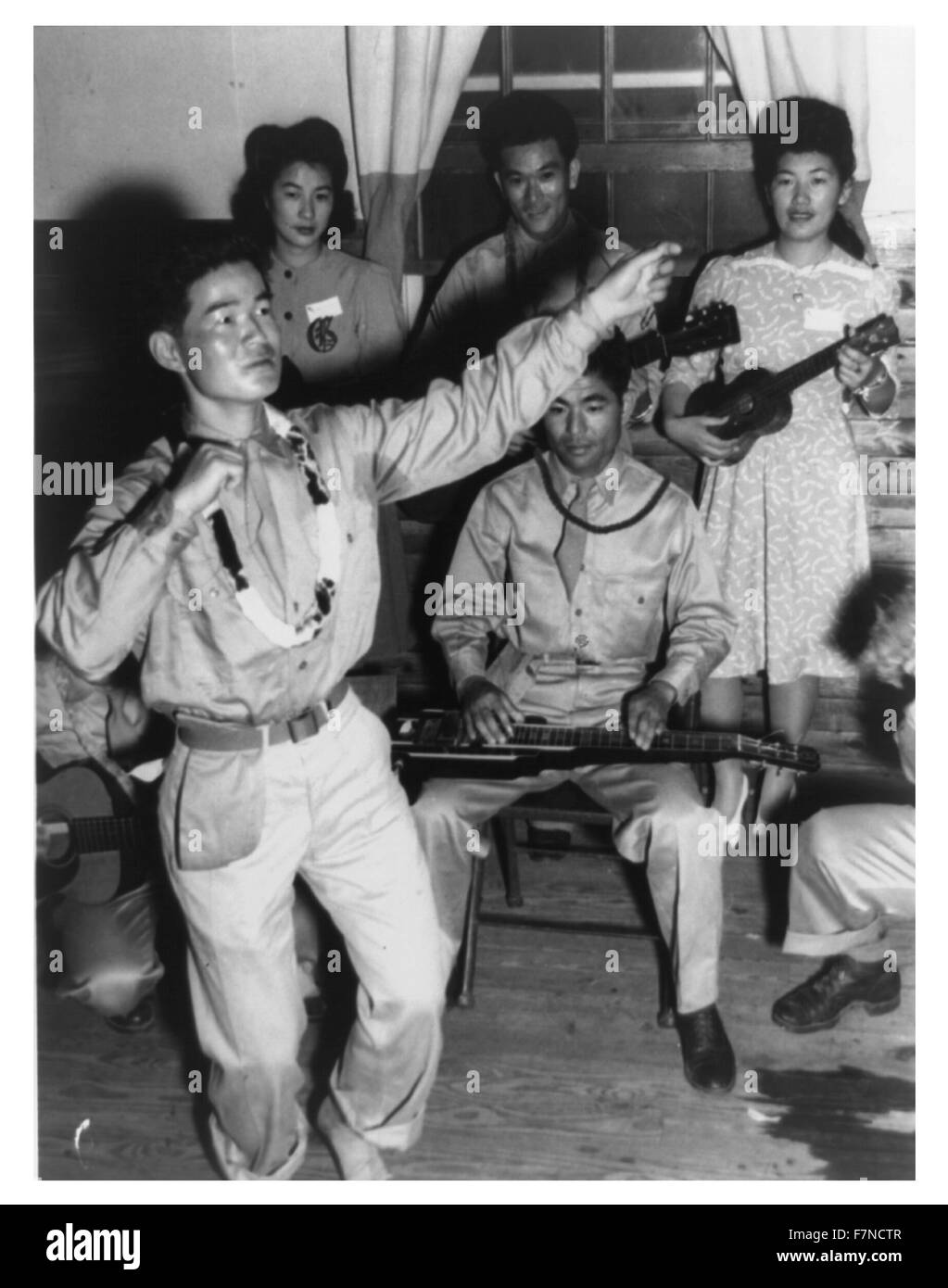 Soldats Américains japonais de l'équipe de combat de la 442e à la danse, Camp Shelby, Mississippi, avec Japanese American girls de Jerome et Rohwer, Centre de réinstallation dans l'Arkansas : Harry Hamada faisant la danse hula et sa guitare-Ukulele Orchestra] Banque D'Images