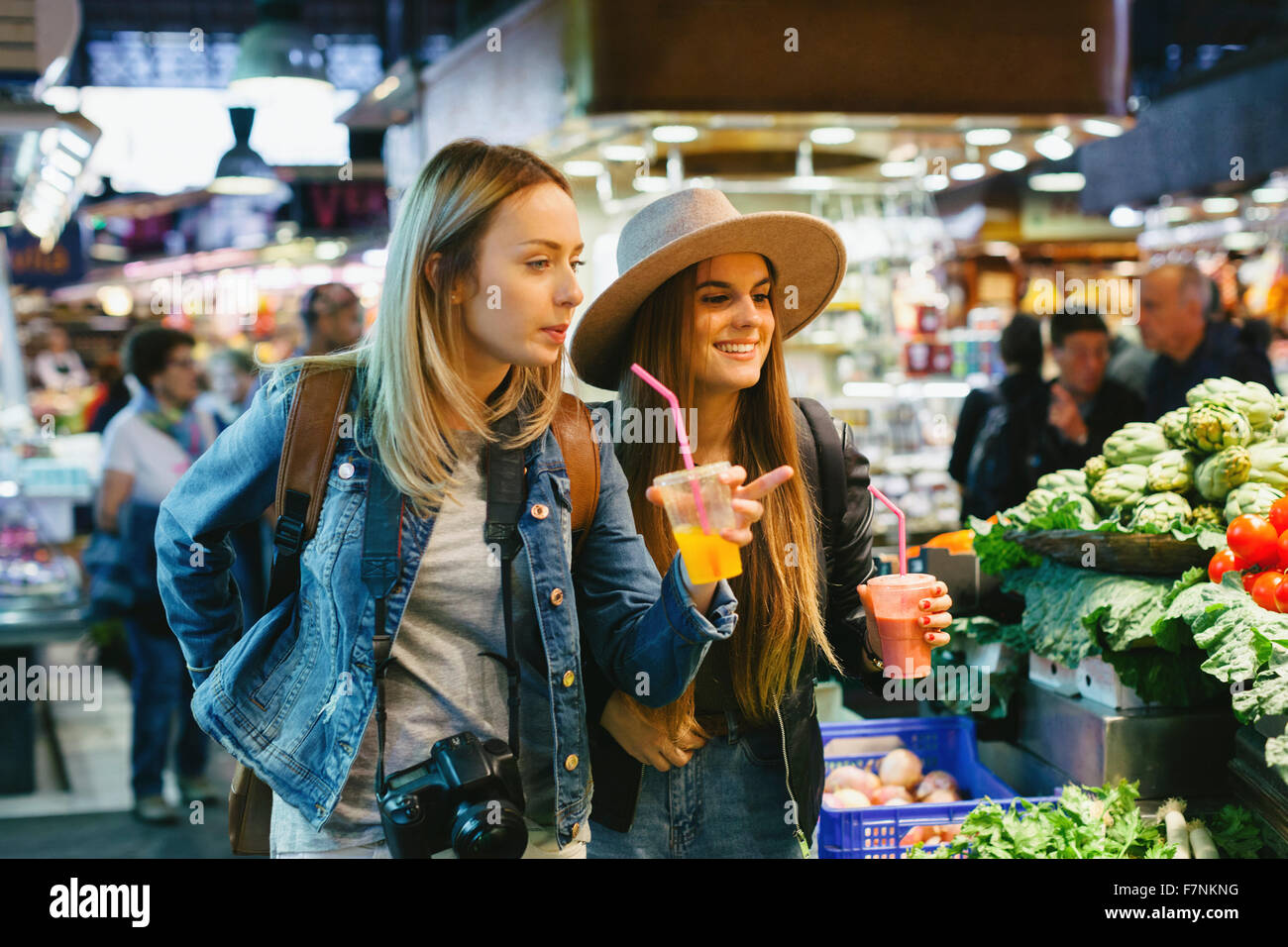 Deux jeunes femmes de boire des smoothies sur un marché Banque D'Images